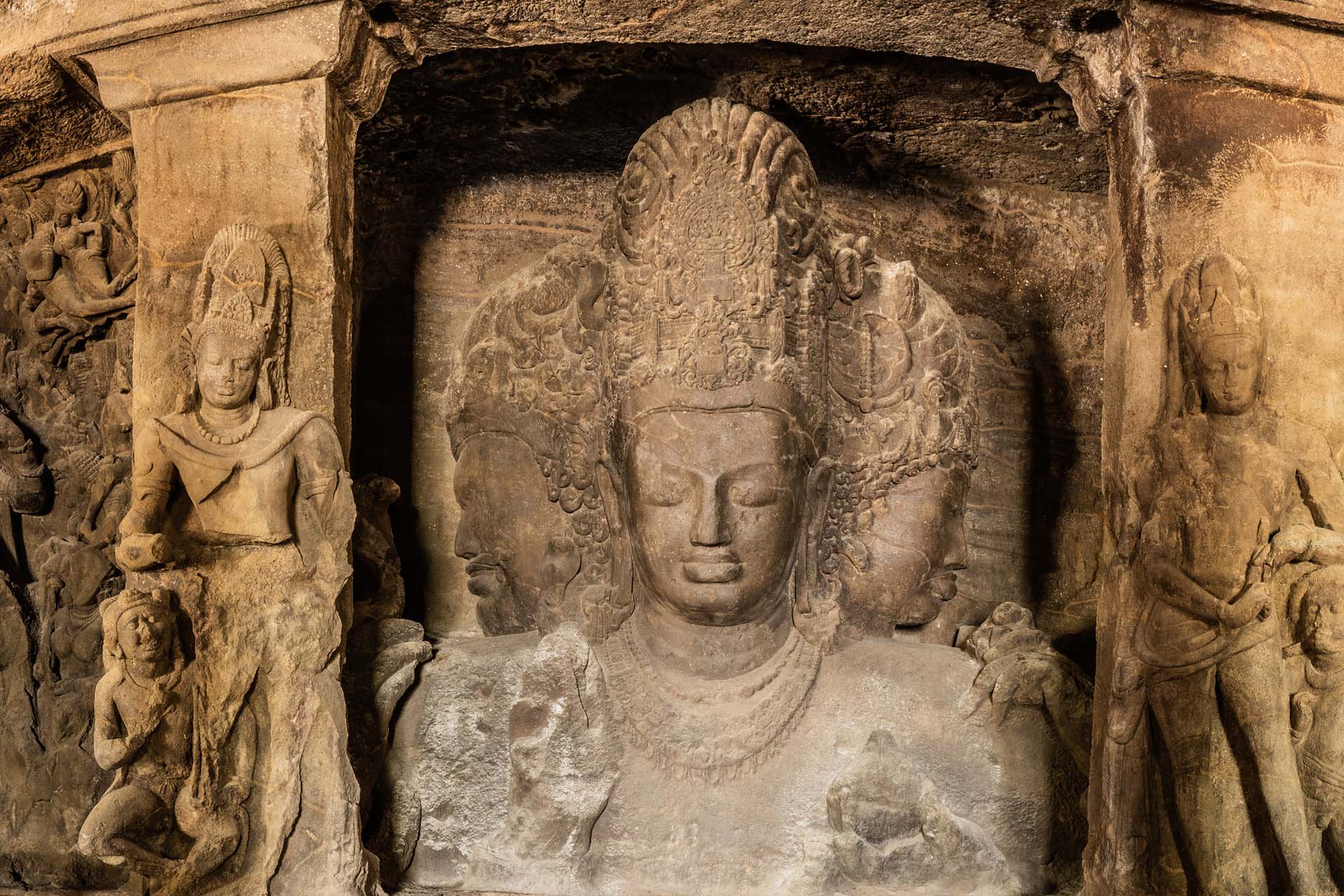 An intricate stone carving showing the three faces of Shiva